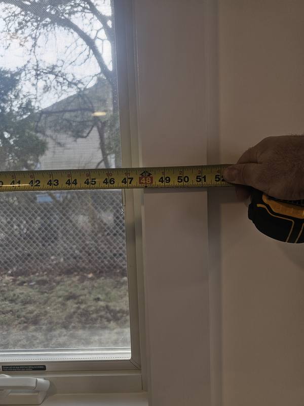 Window opening being measured with a steel tape during a consultation