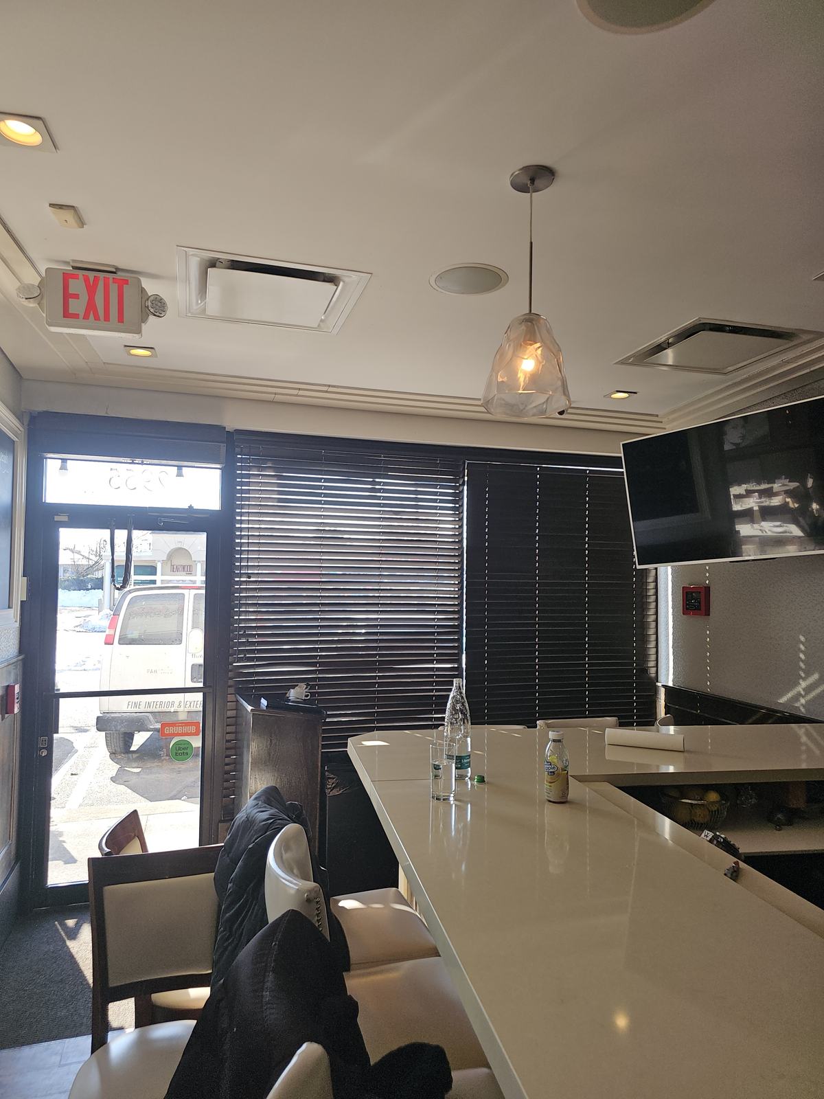 Large shade lowered across the glass frontage of a restaurant interior