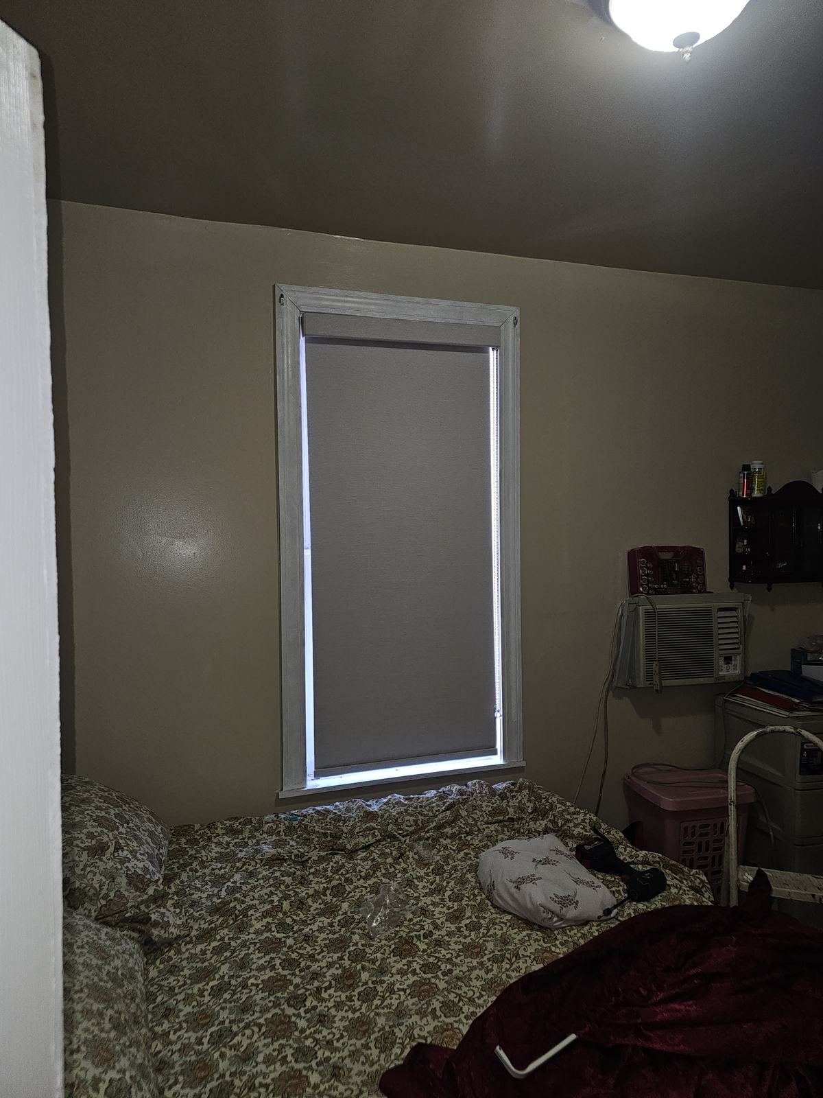 Roller shade fitted to a small out-of-square bedroom window in an older apartment building