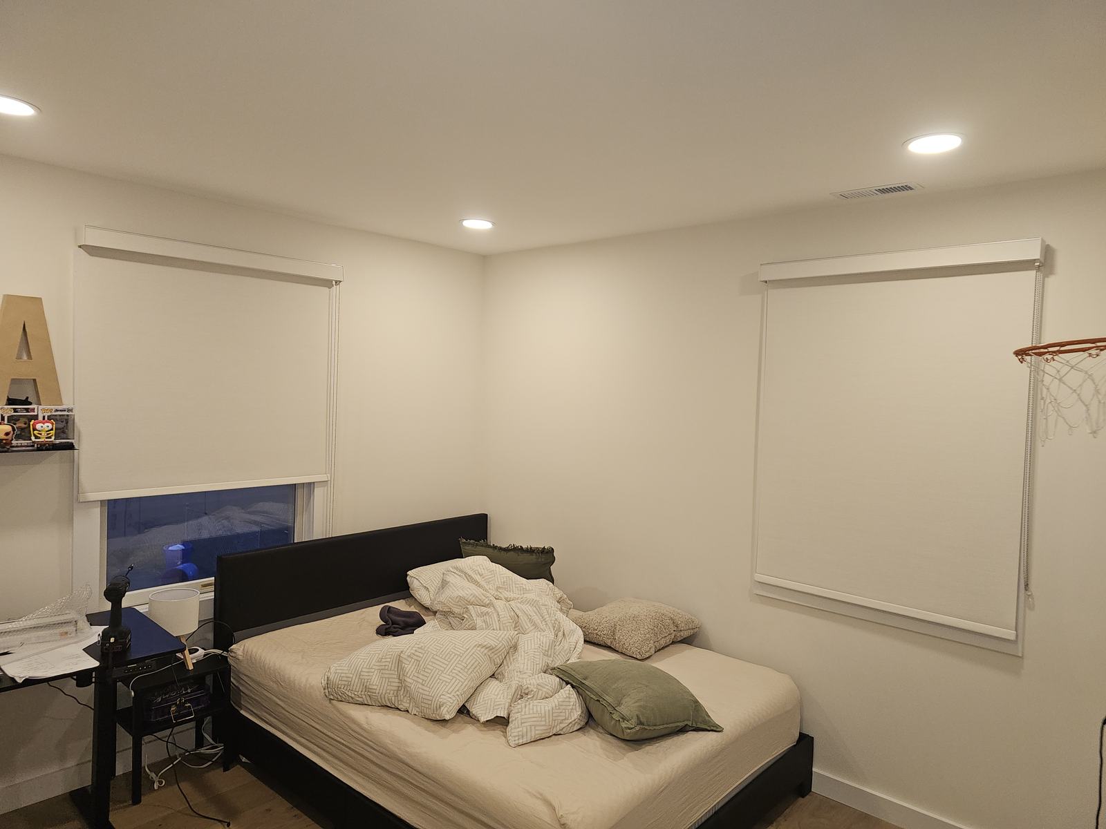 Roller shades installed by ModuShade across two bedroom windows with matching cassettes and aligned hems